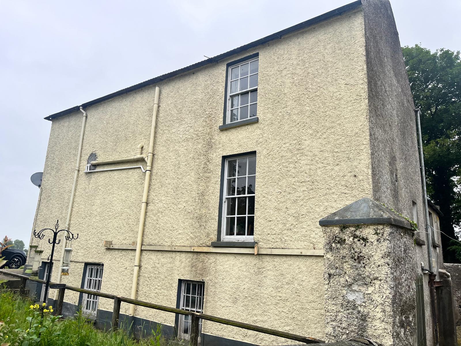 Rear exterior walls of historic Cloughjordan property darkened by moss, grime and biological build-up before cleaning.